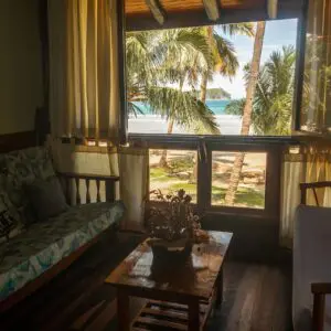 A living room with a couch and table in front of the window.