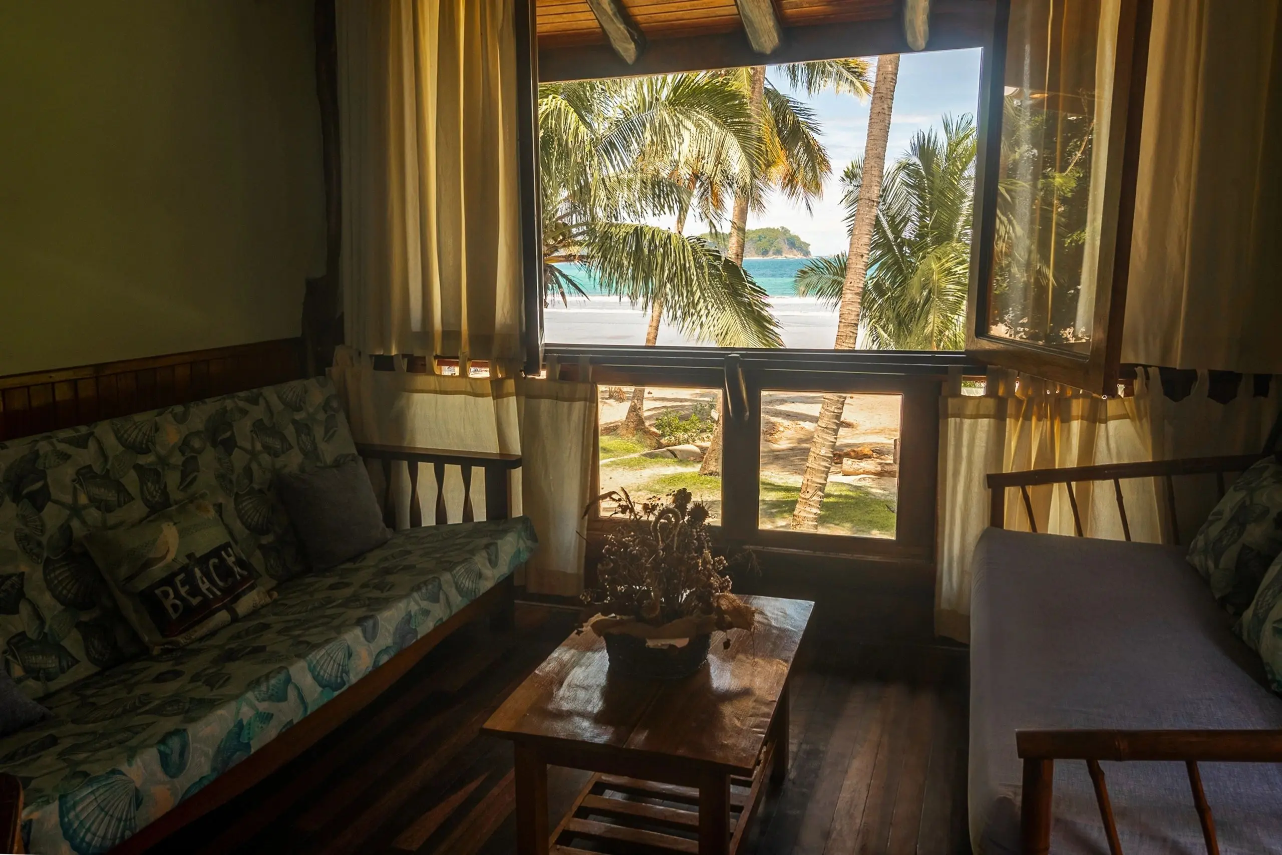 A living room with a couch and table in front of the window.