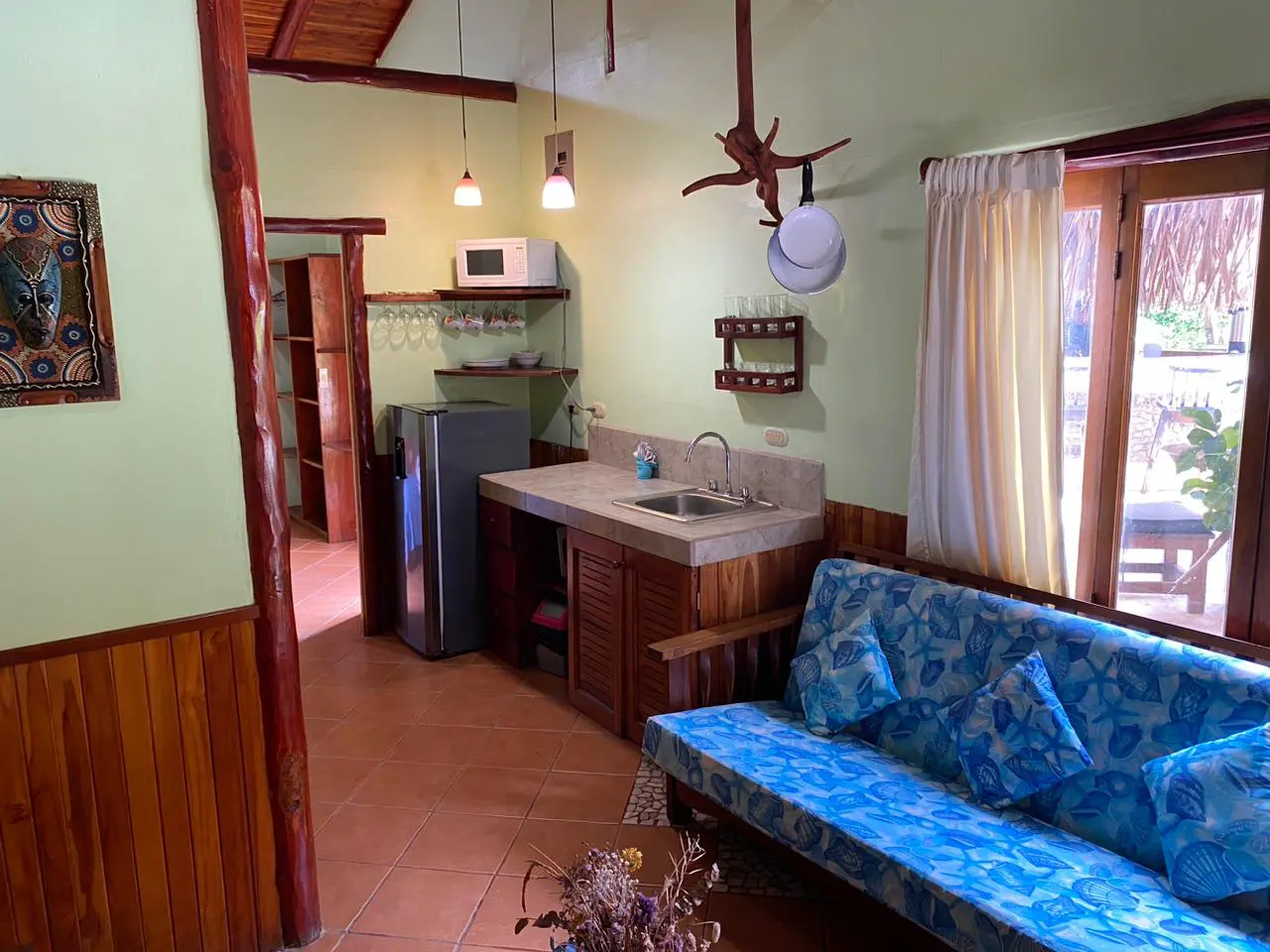 A kitchen with a blue couch and sink