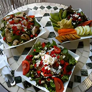 Three bowls of food on a table with a plate