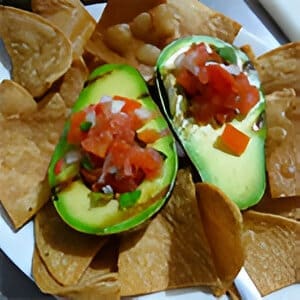 A plate of chips and avocado with salsa.